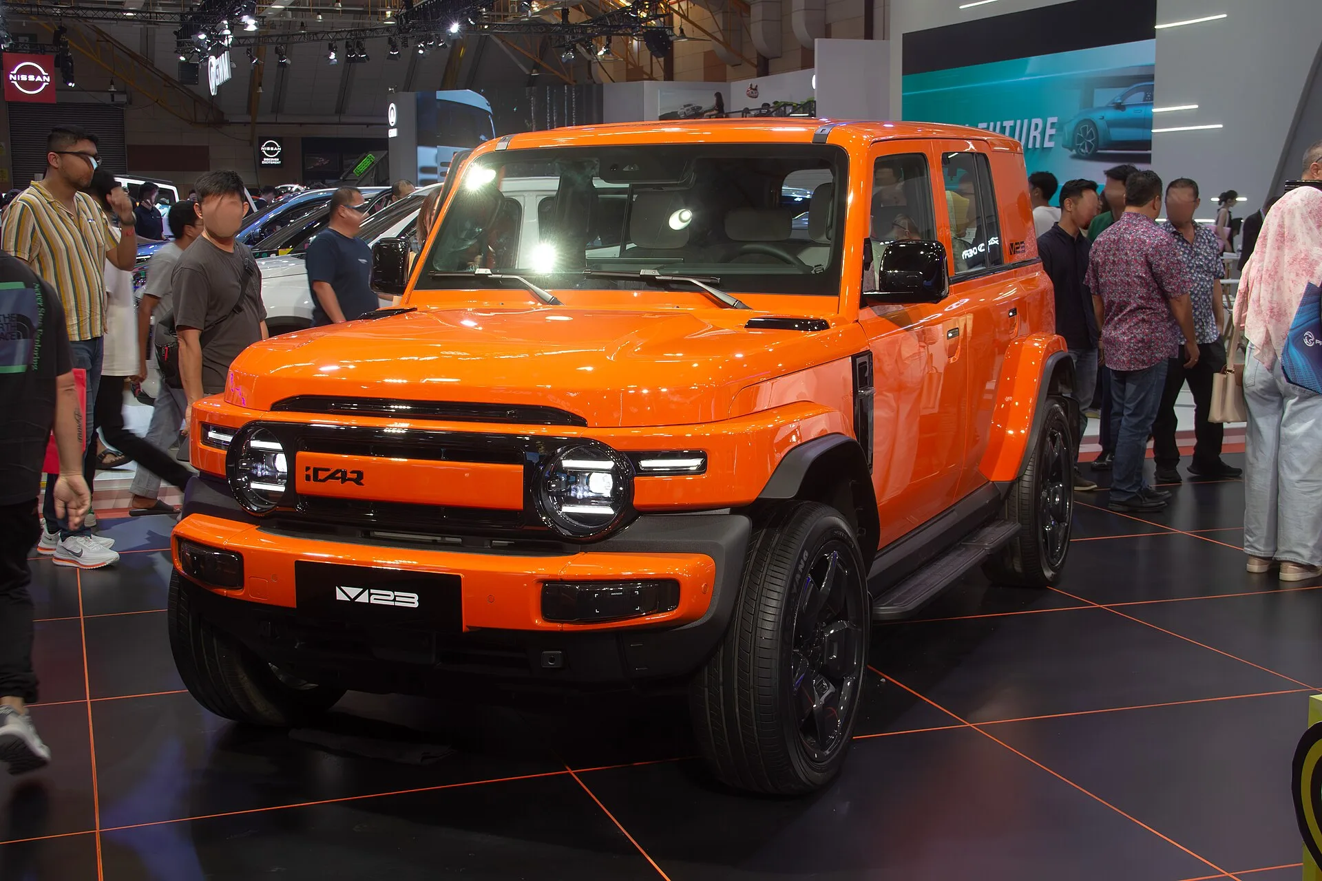 Turuncu renkli kutu tasarımlı iCar V23 elektrikli SUV, bir otomobil fuarında önden görünüm