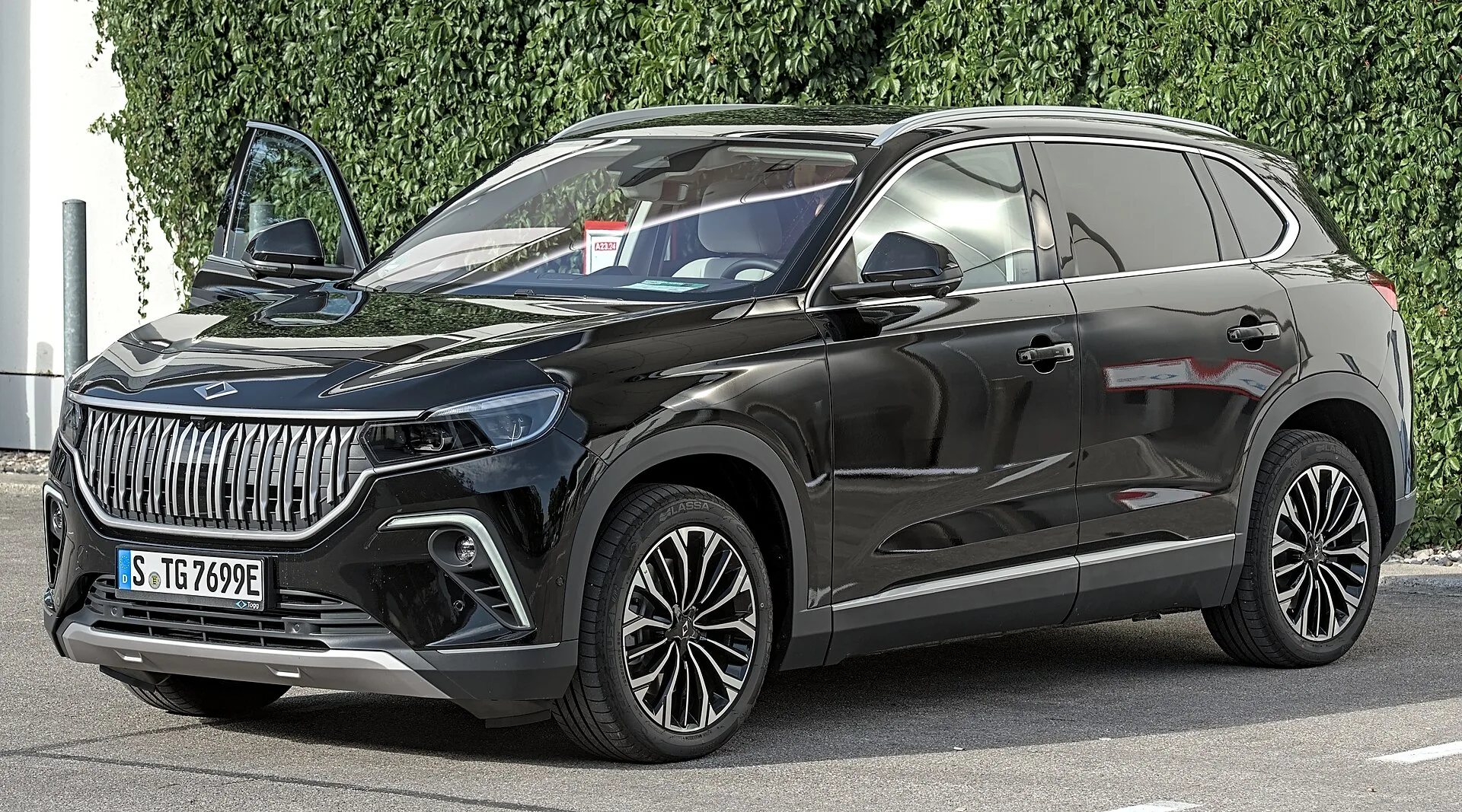 Siyah renkli Togg T10X elektrikli SUV'un yandan ve önden görünümü, sokakta park hâlinde