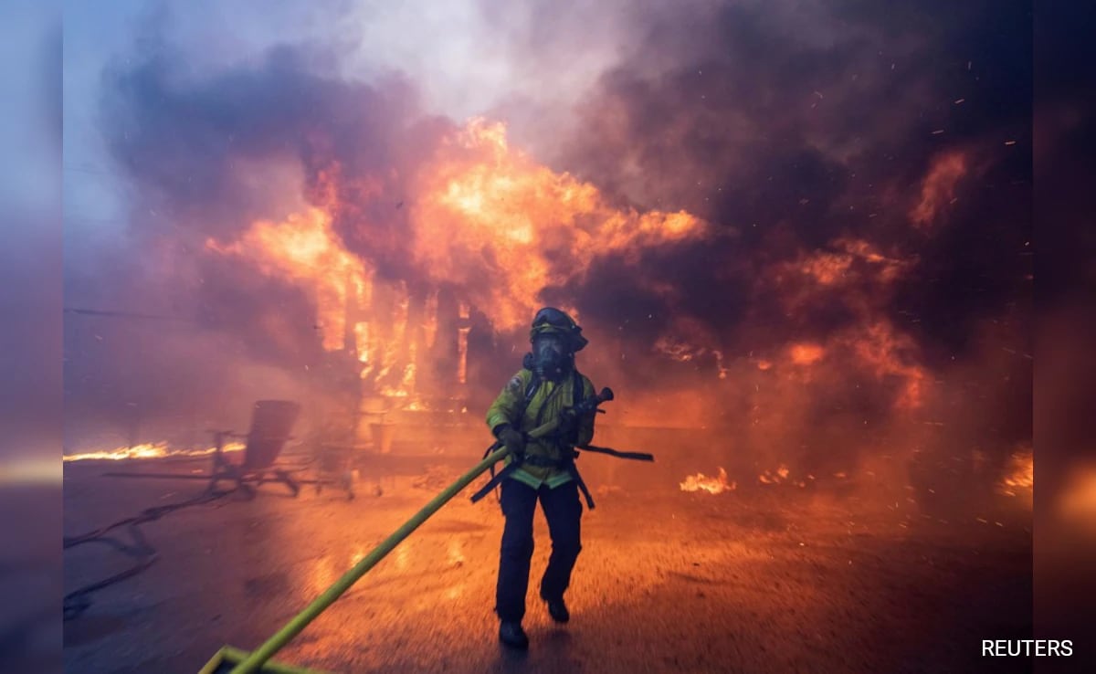 Dramatic depiction of the aftermath of a wildfire in Los Angeles County with smoky skies and firefighters battling flames.