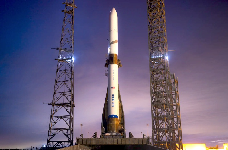 New Glenn rocket on launch pad at Blue Origin facility, technicians preparing for launch amidst cloudy weather conditions.