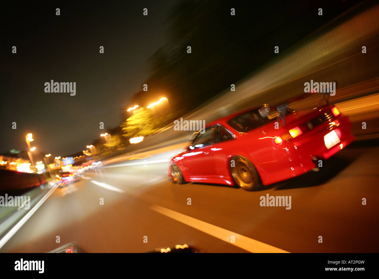 An energetic illustration of a street race in Tokyo at night, showcasing a customized car speeding through neon-lit streets.